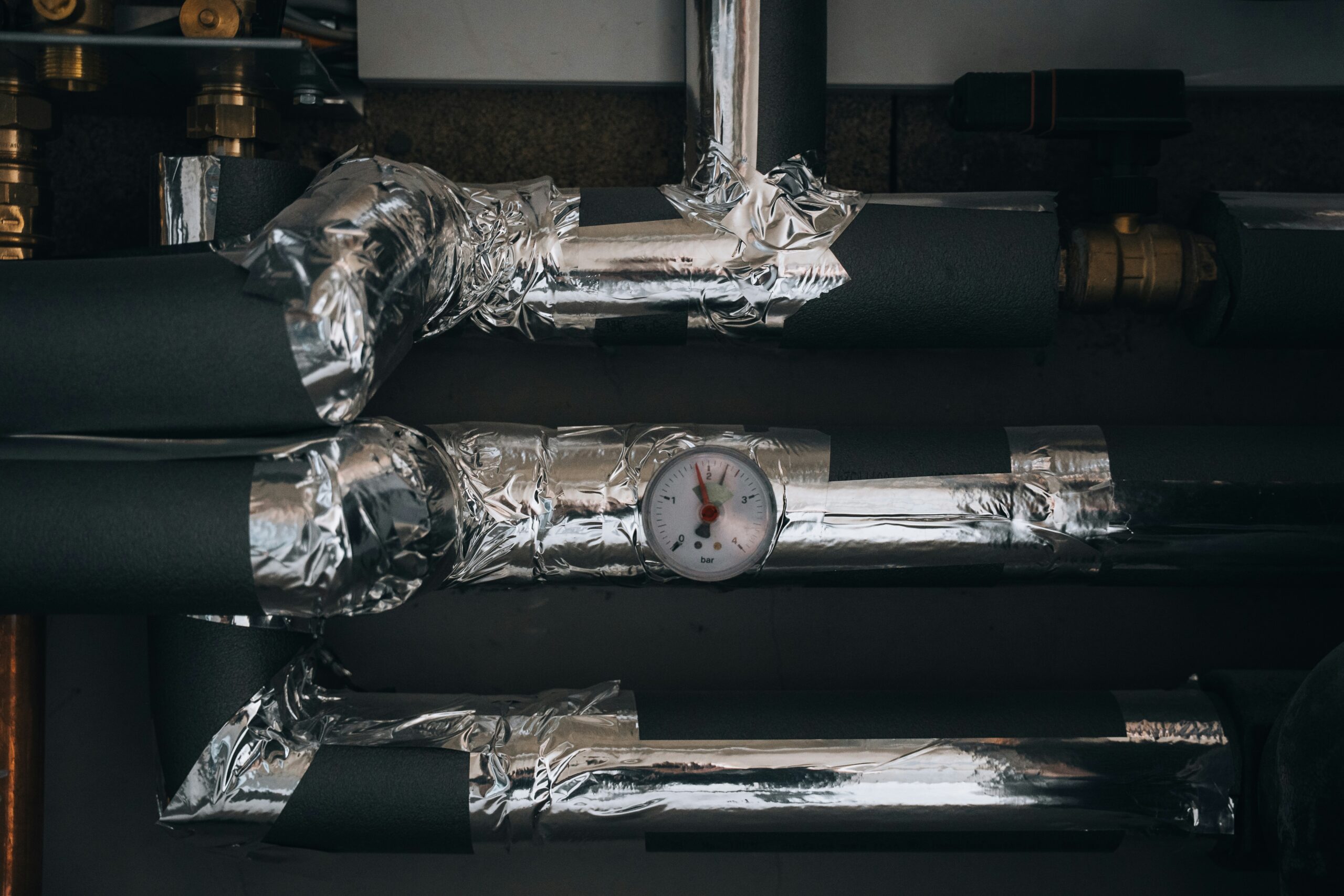 Pipes and equipment are installed on a wall.