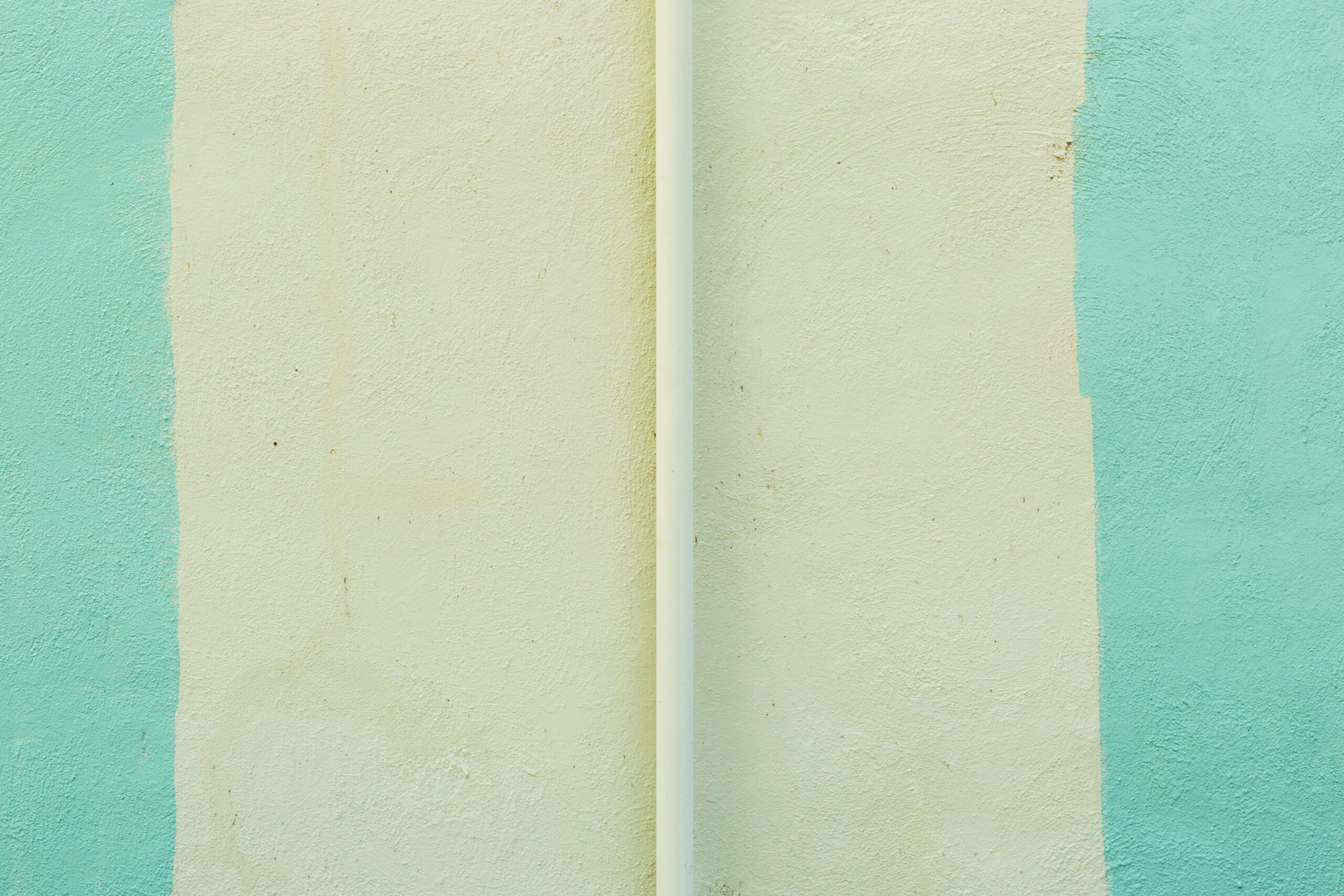 a white surfboard leaning against a blue and green wall